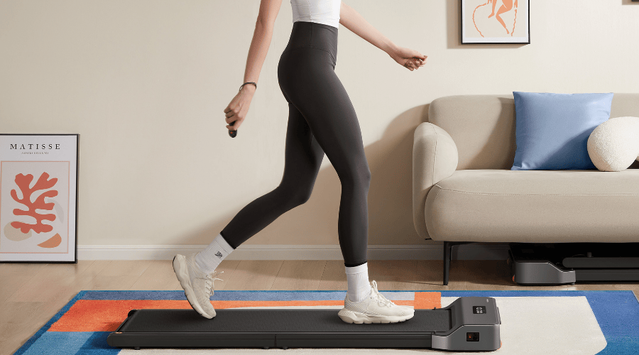 Person walking on a Walking Pad treadmill in a modern living room.