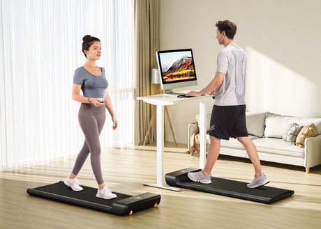 In the living room, a couple are using a folding treadmill to run.