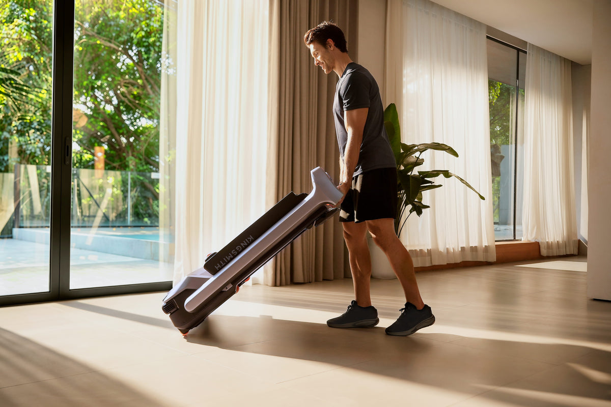 Man moving folded WalkingPad G5I treadmill at home